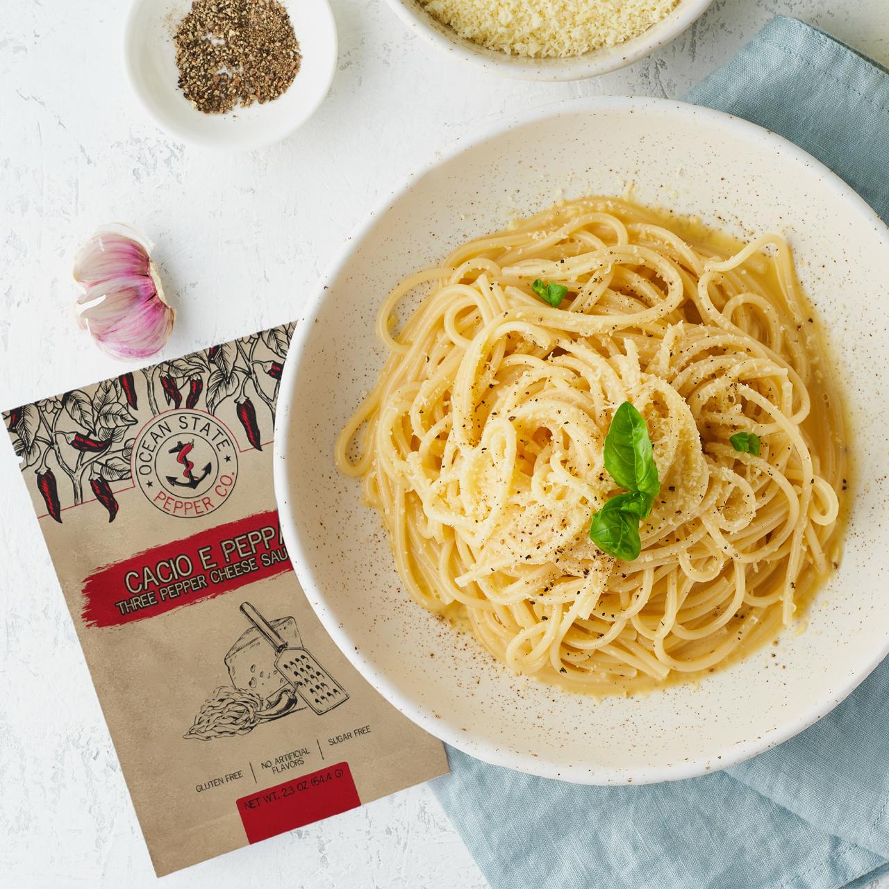 Spaghetti dish with a package of Cacio e Pepe cheese on a light surface.