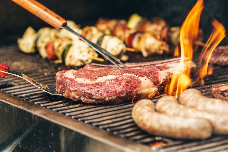 cooking steak and sausages on grill